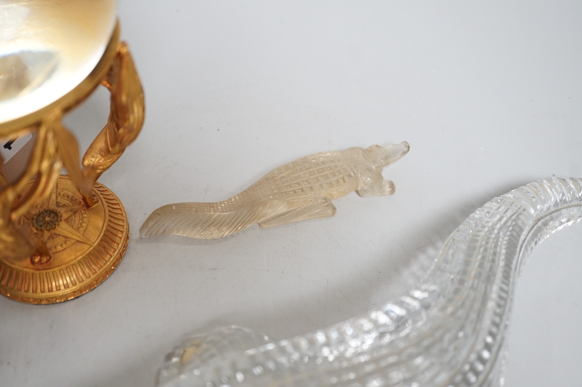 A crystal ball on gilt metal stand, 19cm tall, together with a hermatite crocodile, a jade type crocodile and four other crocodiles